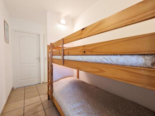 a bedroom with two bunk beds in a room at Résidence Appart Hotel Au Pitot in Biscarrosse-Plage