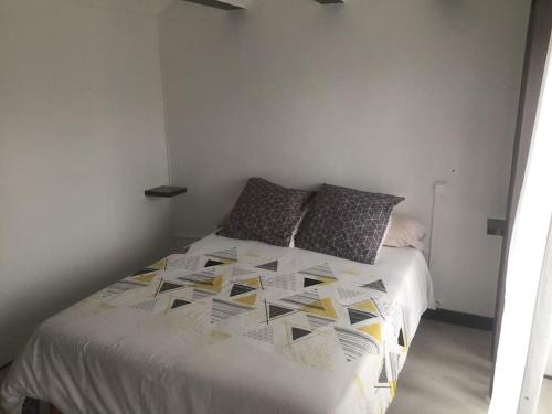 - une chambre avec un lit blanc et des oreillers dans l'établissement Très jolie appartement, à Aiguilhe
