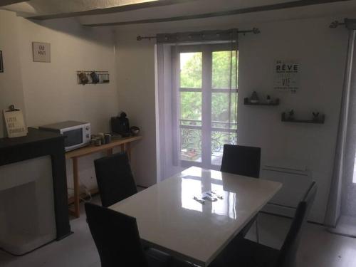 une salle à manger avec une table et des chaises et une fenêtre dans l'établissement Très jolie appartement, à Aiguilhe