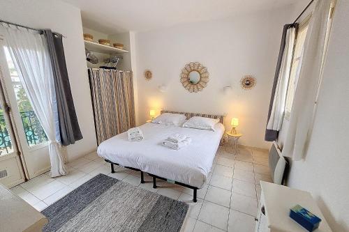 a bedroom with a bed and a large window at HENRI CAMILLE REAL ESTATE - Florida - 2 bedrooms close center in Cannes