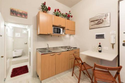 eine kleine Küche mit einer Spüle und einer Mikrowelle in der Unterkunft Reparata- Cozy nest looks for solo traveller in Florenz