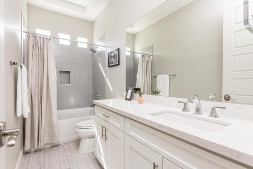 a white bathroom with a sink and a toilet at Camelback Dwelling - Private Pool/Spa - In Old Town in Scottsdale