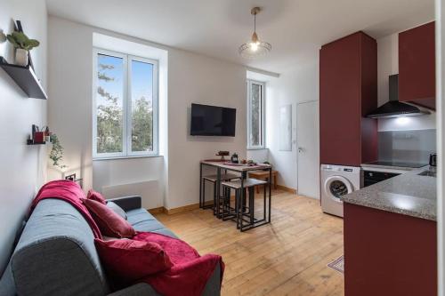 a living room with a couch and a kitchen at Repaire du Bagnérais in Bagnères-de-Bigorre