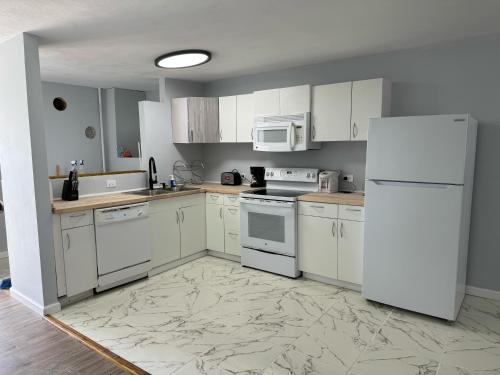 a kitchen with white appliances and a white refrigerator at 13th Floor Apartment with Nice View in Bahía A in San Juan