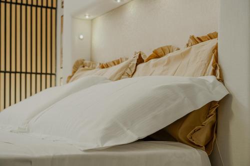 a bed with several pillows on top of it at Cascina Ridolfi - Il Nido d'Amore in Spello