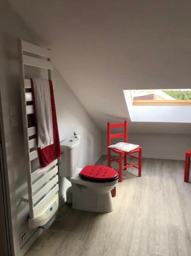 a bathroom with a toilet and a red chair at Chambre et salle d'eau privées dans maison de ville in La Roche-sur-Yon