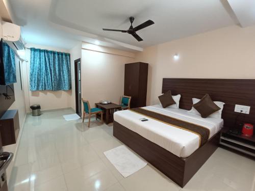 Hotel Classic Comfort في بانغالور: غرفة نوم بسرير كبير مع مروحة سقف