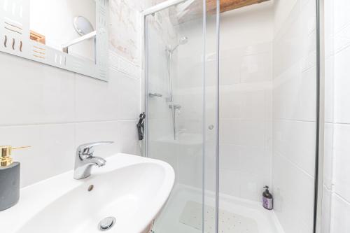 a white bathroom with a sink and a shower at The Byre, Melmerby in Gamblesby