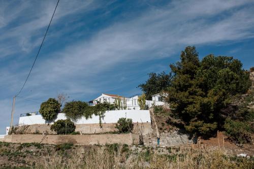 une maison au sommet d'une colline avec des arbres dans l'établissement Finca La Herradura, à La Herradura