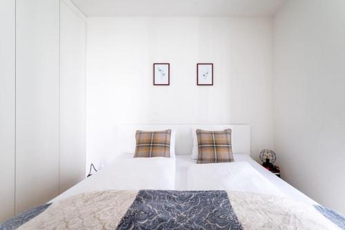 1 dormitorio blanco con 1 cama con 2 almohadas en HM • Smart Studio with Terrace, en Viena