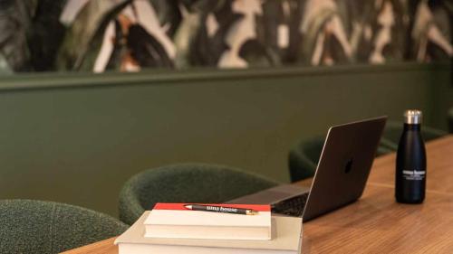 a bottle of wine and a book and a laptop on a table at Uma House by Yurbban South Beach in Miami Beach