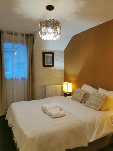 Un dormitorio con una cama con una toalla blanca. en La Maison Olivia, en La Rivière-Saint-Sauveur