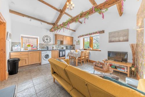 a living room with a couch and a kitchen at The Byre, Melmerby in Gamblesby