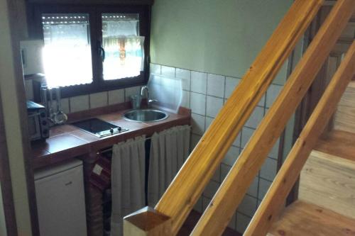 una pequeña cocina con fregadero y ventana en One bedroom house with wifi at Bermiego, en Bermiego