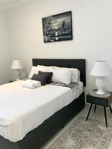 a bedroom with a large bed with two night stands at Modern apartment, a home away from home 266 in Summerstrand