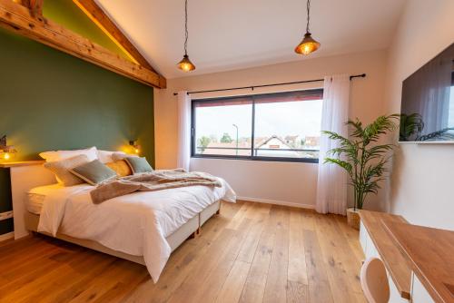 ein Schlafzimmer mit einem Bett und einem großen Fenster in der Unterkunft Studio Le Vau in Bagneux