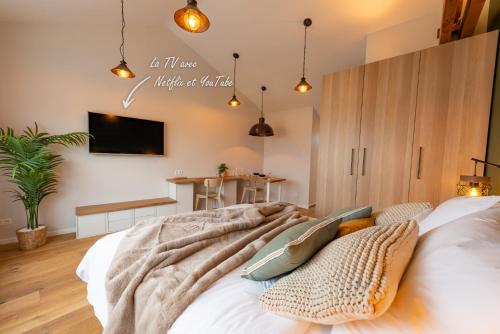 - une chambre avec un lit et une télévision murale dans l'établissement Studio Le Vau, à Bagneux