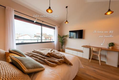 Schlafzimmer mit einem Bett, einem Schreibtisch und einem Fenster in der Unterkunft Studio Le Vau in Bagneux