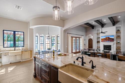 a kitchen with a large sink and a living room at Luxe Poolside Paradise - Resort Style Yard in Scottsdale