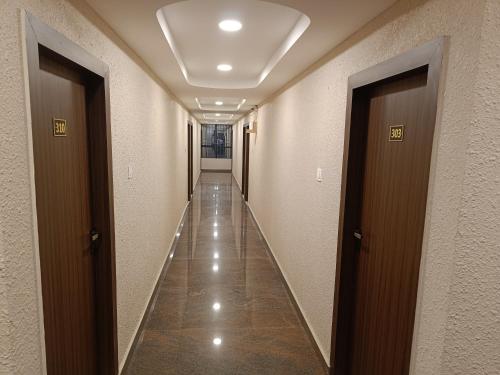 a corridor of a hallway with two doors and a long hallway at Hotel Classic Comfort in Bengaluru