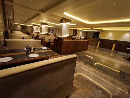 a restaurant with tables and chairs in a room at Hotel Classic Comfort in Bengaluru