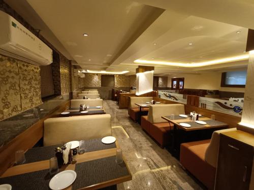 a restaurant with many tables and chairs at Hotel Classic Comfort in Bengaluru