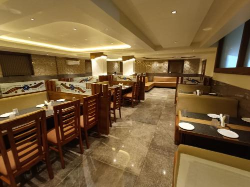 a dining room with tables and chairs in a restaurant at Hotel Classic Comfort in Bengaluru