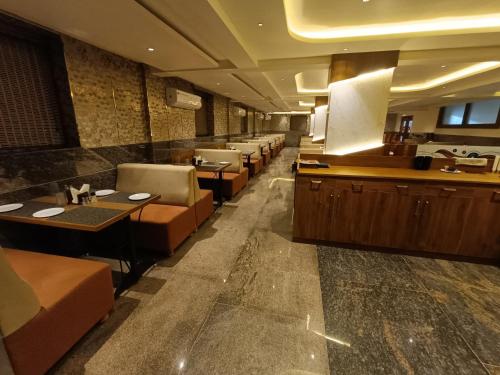 a restaurant with tables and chairs in a room at Hotel Classic Comfort in Bengaluru