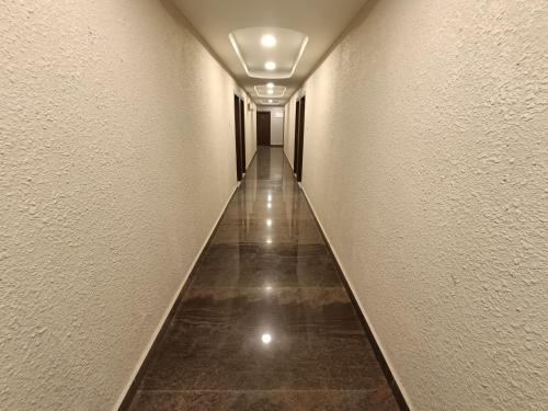 a hallway with a long corridor with white walls at Hotel Classic Comfort in Bengaluru