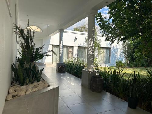 un porche de una casa blanca con plantas en Elegant Guest House Sandton, en Johannesburgo