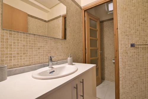 a bathroom with a sink and a mirror at The Place To Be - Agadir Centre in Agadir