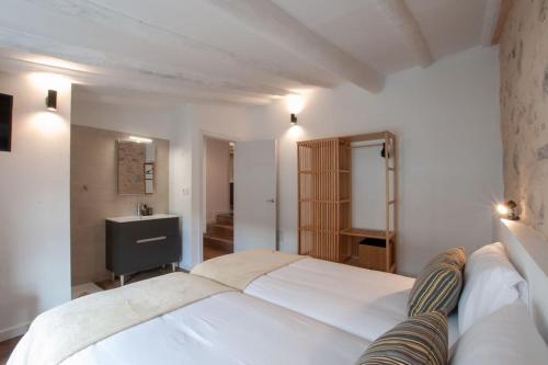 a bedroom with a large white bed and a bathroom at La Casa de San Juan - Tenesor in Telde