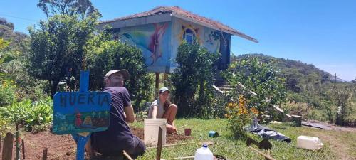 un hombre y una mujer parados frente a una casa en Finca Neblina del Bosque en Estelí