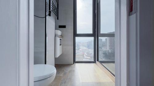 ein Bad mit einem WC und einem großen Fenster in der Unterkunft Lux Apartments G62 in Tbilisi City