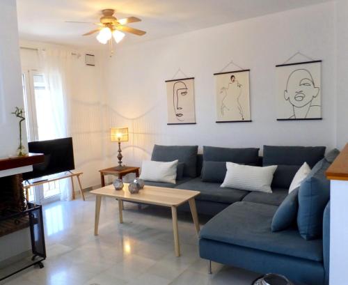 ein Wohnzimmer mit einem blauen Sofa und einem Tisch in der Unterkunft Aljamar 24 Comfortable house near Burriana Beach in Nerja
