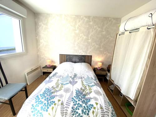 una camera con un letto e due tavoli con lampade di Charmant appartement rénové à neuf 4 personnes à Hennebont - MATÉO a Hennebont