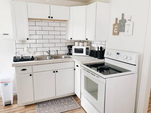 a white kitchen with a sink and a microwave at Stylish & Cozy Home in Dayton-Close to Everything! in Dayton