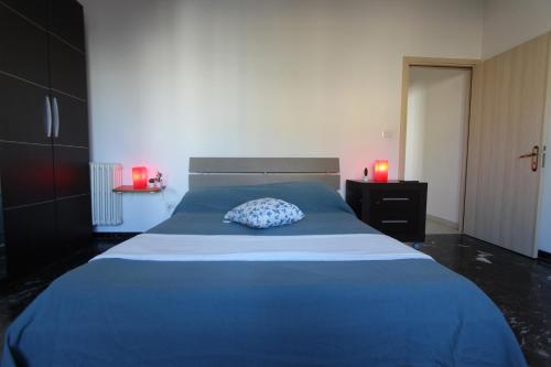 サルヴェにあるCasa Elena Giallaのベッドルーム1室(青いベッド1台、赤いキャンドル2本付)