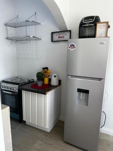 een keuken met een witte koelkast en een fornuis bij The Shelton - Blossom’s Rest in Montego Bay