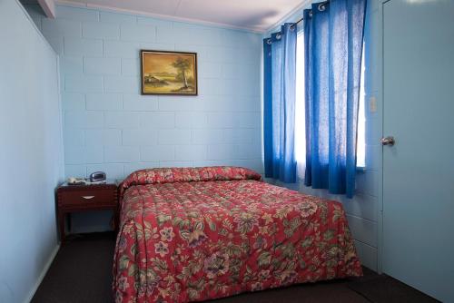 a small bedroom with a bed and a window at Artesian Motor Inn in Coonamble