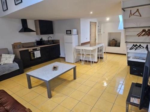 a living room with a table and a kitchen at La petite bulle in Villeneuve-sur-Yonne