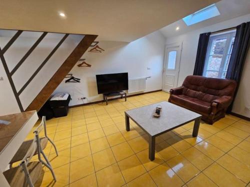 a living room with a couch and a table at La petite bulle in Villeneuve-sur-Yonne