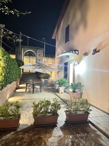 a patio at night with a table and umbrella at Villa Giusi in Tropea