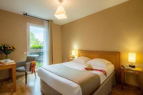 a hotel room with a bed and a window at Résidence Services Seniors DOMITYS - Les Galopins in Trélissac