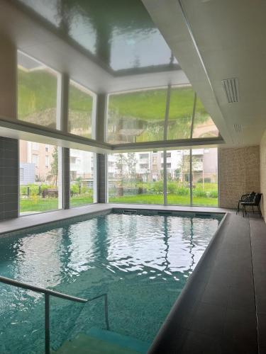 a large swimming pool in a building with windows at Résidence Services Seniors DOMITYS - Les Galopins in Trélissac