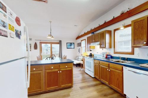 a kitchen with wooden cabinets and a white refrigerator at The Beacon 95 in Avon