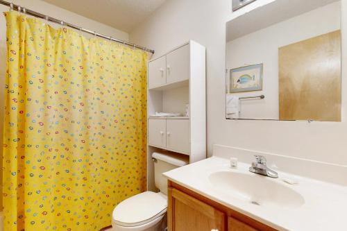 a bathroom with a yellow shower curtain and a sink at The Beacon 95 in Avon