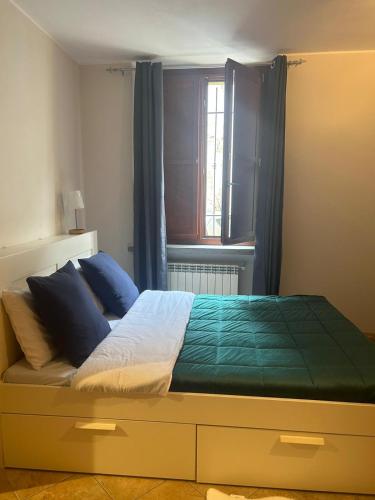 um quarto com uma cama com almofadas azuis e uma janela em modern apartment Legnano em Legnano