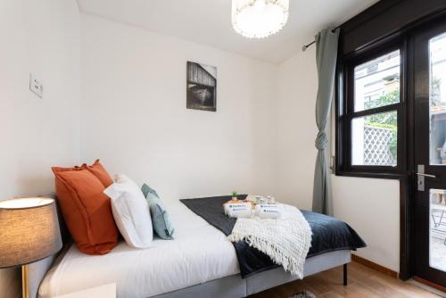 - une chambre dotée d'un lit avec des oreillers orange et bleu dans l'établissement Host Wise - Spacious Sunny House with terrace & BBQ, à Vila Nova de Gaia