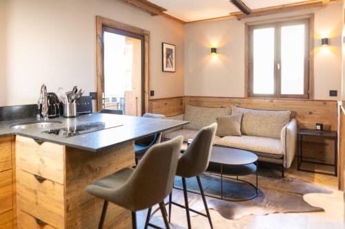 un salon avec une table, des chaises et un canapé dans l'établissement Apartment with terrace and parking heart of Megève, à Megève
